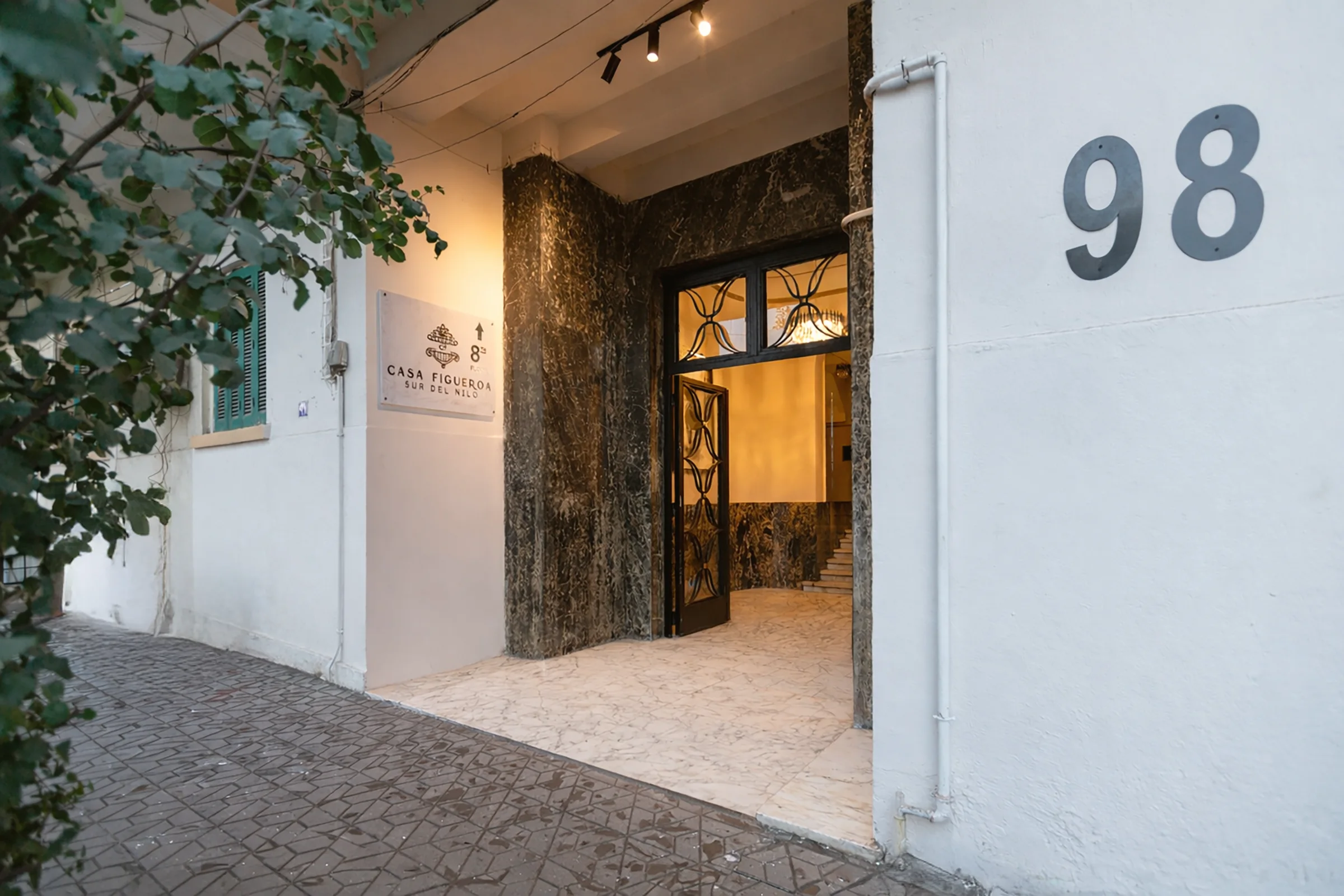 The lit marble entrance of 98 Nile Street at dusk